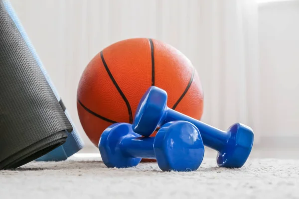 Dumbbells and ball on floor in room