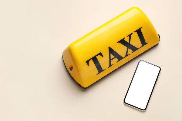 Κίτρινη Πινακίδα Οροφής Ταξί Και Κινητό Τηλέφωνο Μπεζ Φόντο — Φωτογραφία Αρχείου