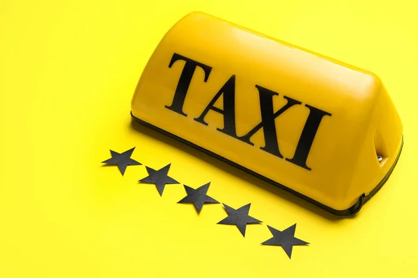 黄色の背景にタクシーの屋根のサインと紙の星 — ストック写真