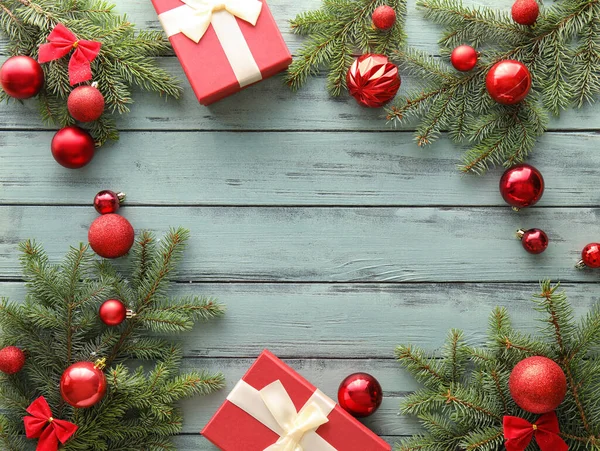 モミの枝 美しいクリスマスボールと色の木製の背景の贈り物と構成 — ストック写真