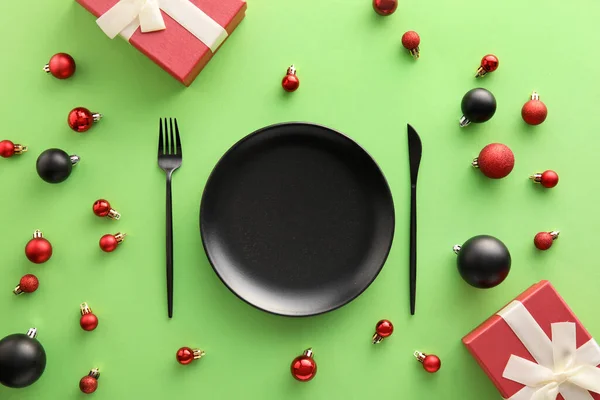 緑の背景にクリスマスプレゼントやボールと美しいテーブルの設定 — ストック写真