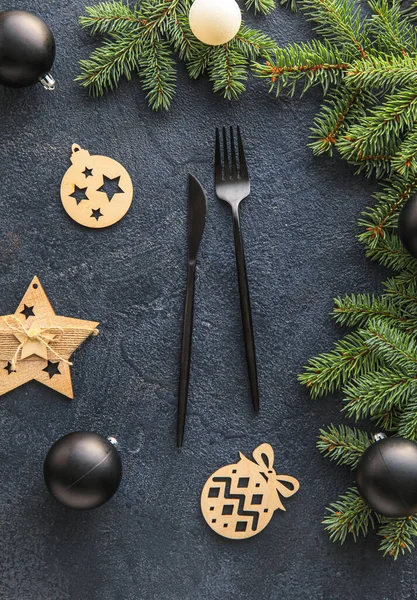 Schwarzes Besteck Mit Weihnachtsdekor Und Tannenzweigen Auf Dunklem Hintergrund — Stockfoto