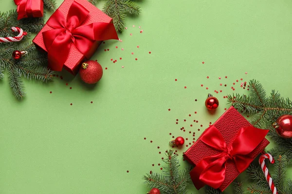 Komposition Mit Tannenzweigen Weihnachtsgeschenken Und Dekorationen Auf Grünem Hintergrund — Stockfoto