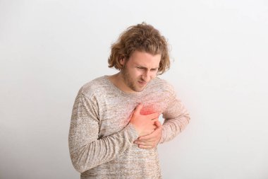 Genç adam arka planda kalp krizi geçiriyor.