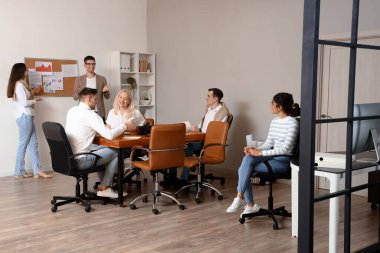 İş arkadaşları ofiste yaptıkları toplantıda sunum yapıyorlar