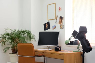 Ofisinde bilgisayar ve profesyonel ekipman bulunan fotoğrafçı işyeri