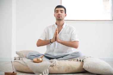 Tibet 'te şarkı söyleyen adam evde meditasyon yapıyor.