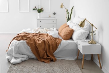 Açık tenli yatak odasının içi çekmecelerle dolu.