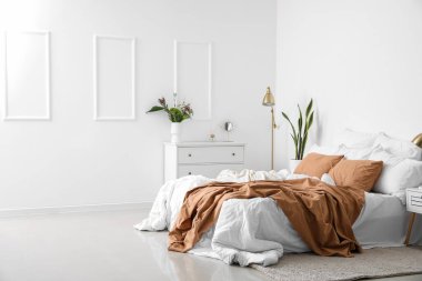 Açık tenli yatak odasının içi çekmecelerle dolu.