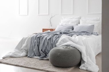 Işıl ışıl yatak odasının içi ahşap masa ve puf.