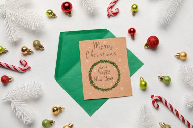 Tebrik kartı ve ışık arkaplanındaki Noel süslemeleri ile kompozisyon