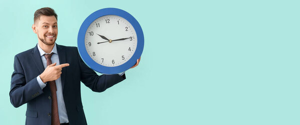 Businessman with big clock on light blue background. Time management concept