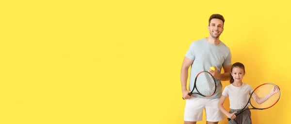 Kleines Mädchen Und Ihr Vater Mit Tennisschlägern Auf Gelbem Hintergrund — Stockfoto