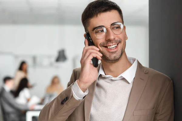 Bonito Empresário Falando Por Telefone Celular Durante Reunião Escritório — Fotografia de Stock