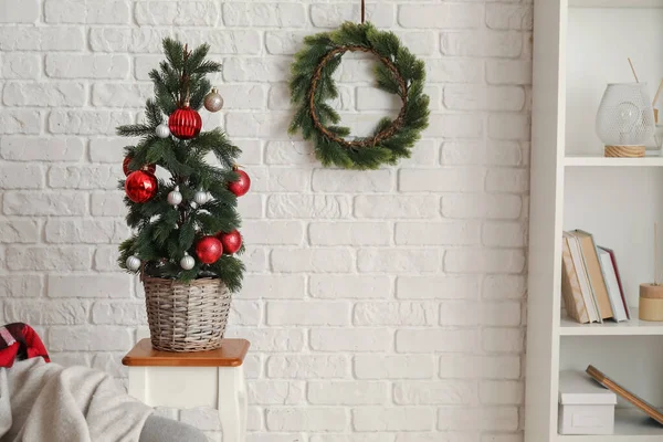 白いレンガの壁の近くのテーブルの上にポットの美しいクリスマスツリー — ストック写真