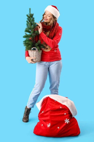 Young Woman Santa Hat Christmas Tree Bag Blue Background — Stock Photo, Image