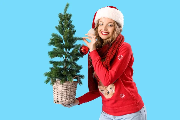 Νεαρή Γυναίκα Σάντα Καπέλο Χριστουγεννιάτικο Δέντρο Μπλε Φόντο — Φωτογραφία Αρχείου