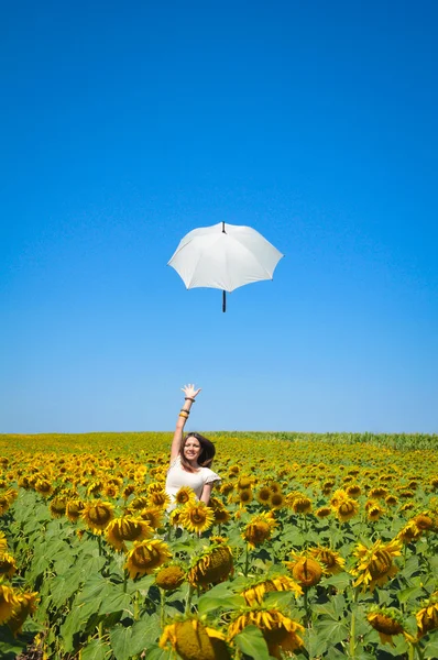 Young woman with umbrella on field in sunflower — Stock Photo, Image
