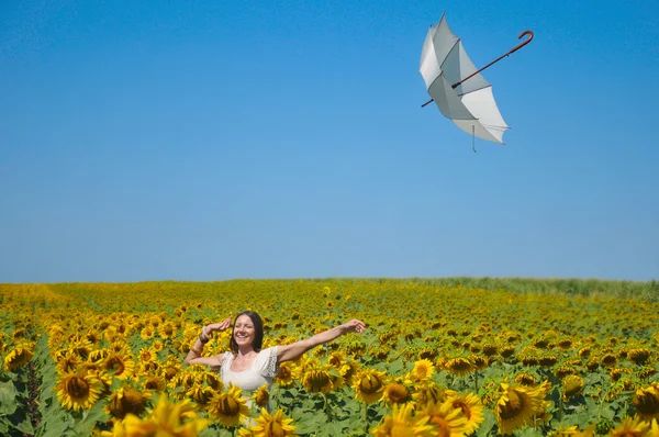 Jonge vrouw met paraplu op veld in zonnebloem — Stockfoto