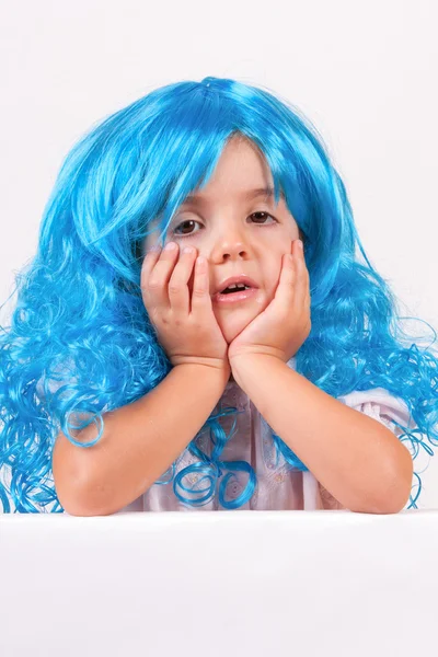Маленькая девочка с голубыми париками — стоковое фото