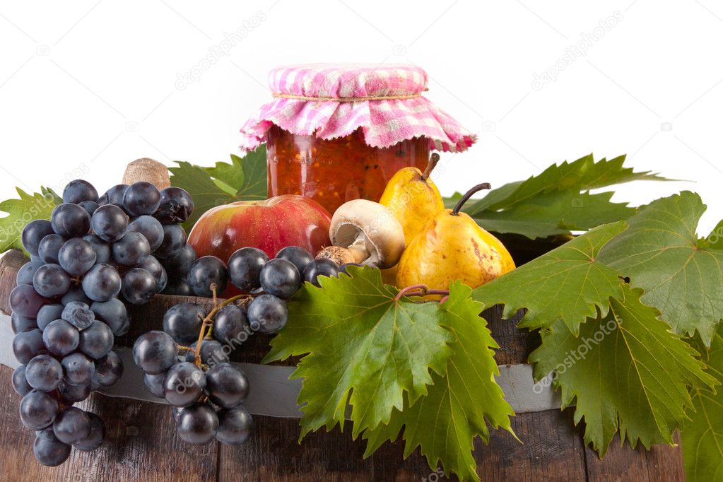 Jar of tomato with autumn vegetables and fruits on a white background