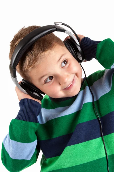 Niño sonriente escuchando música en el auricular —  Fotos de Stock