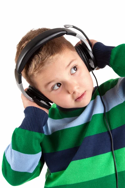 Lächelnder kleiner Junge hört Musik im Kopfhörer — Stockfoto