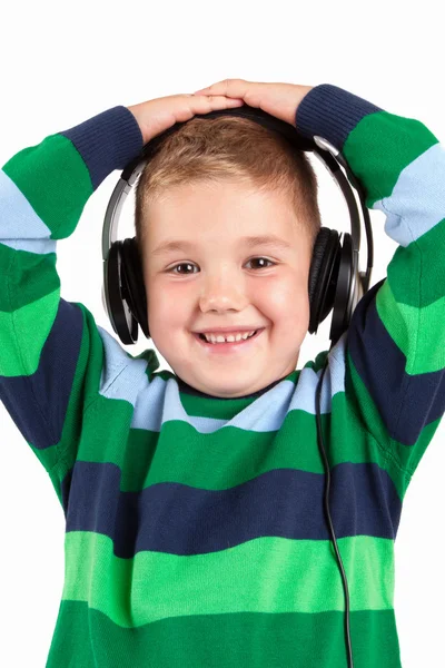 Niño sonriente escuchando música en el auricular — Foto de Stock