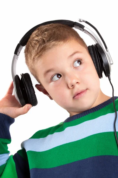 Niño sonriente escuchando música en el auricular — Foto de Stock