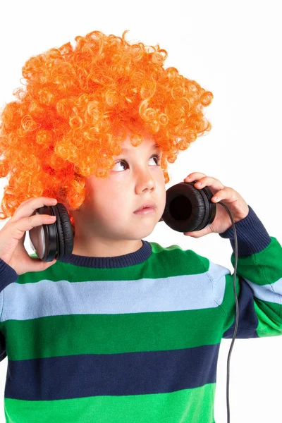 Niño sonriente escuchando música en el auricular —  Fotos de Stock
