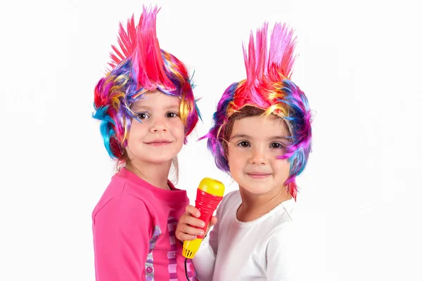 Дети поют с красочными париками — стоковое фото
