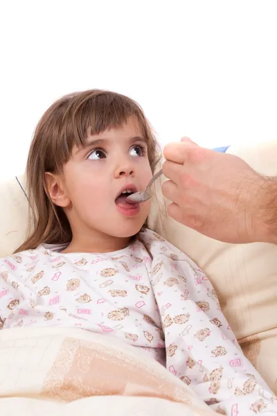 Child takes vitamins by spoon — Stock Photo, Image