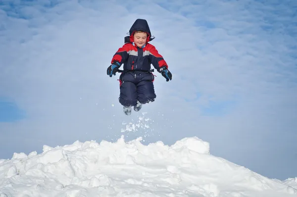 Happy little kid is playing in snow — Stock Photo, Image