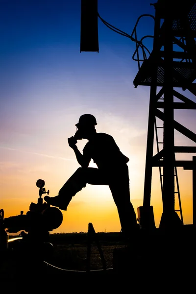 Silhouette eines Ölarbeiters — Stockfoto