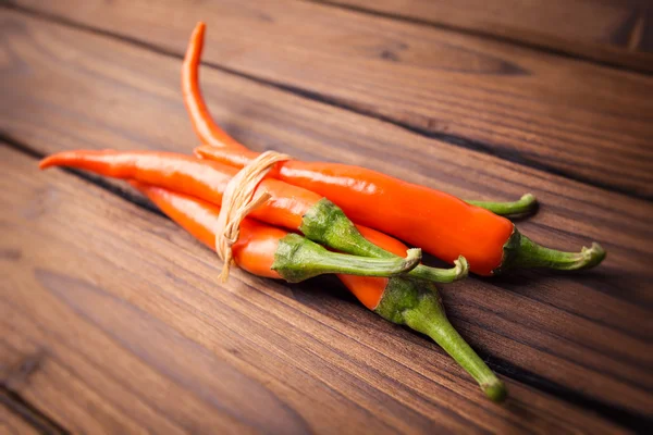 Chili peppers on a wooden table — Stock Photo, Image