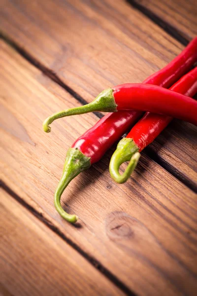 Chili peppers on a wooden table — Stock Photo, Image