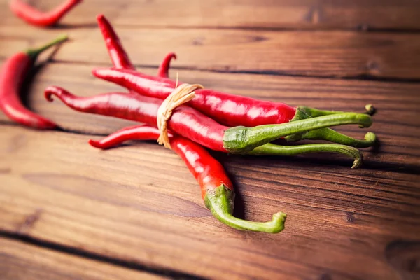 Chili peppers on a wooden table — Stock Photo, Image