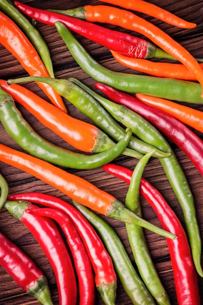 Chili peppers on a wooden table — Stock Photo, Image