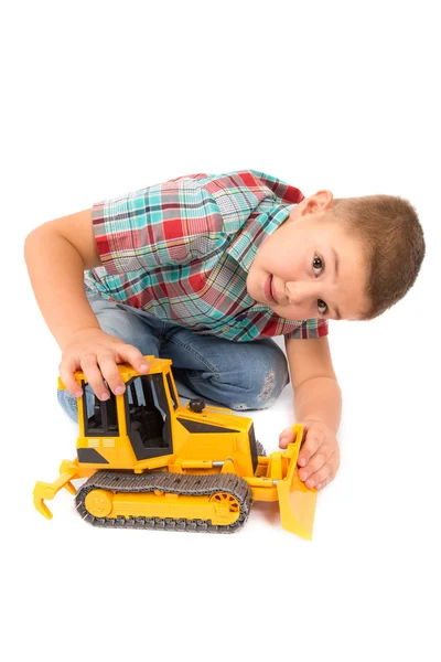 Kleine jongen speelt met speelgoed trekker — Stockfoto