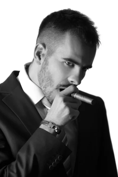 Attractive businessman is smoking a cigar — Stock Photo, Image