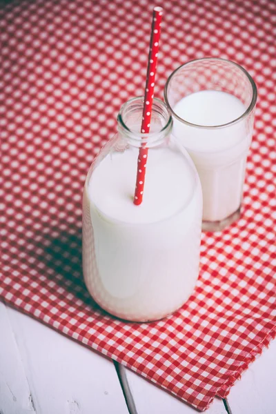 Färsk mjölk och glas på träbord — Stockfoto