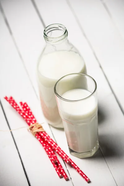 Färsk mjölk och glas på träbord — Stockfoto