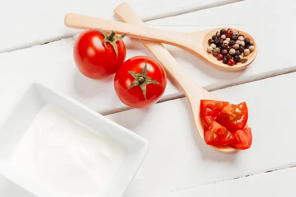 Tomato on wooden spoon — Stock Photo, Image