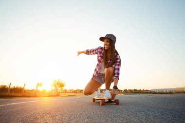 Güzel genç kız güneşli bir havada sörf tahtasına oturur..