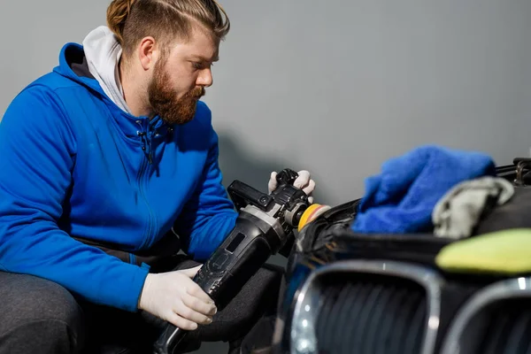 Car headlight cleaning with power buffer machine at service station