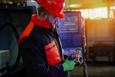 Kalite kontrol imalatı. Bir mühendisin elleri metal bir parçayı dijital vernier kalibre ile ölçer.