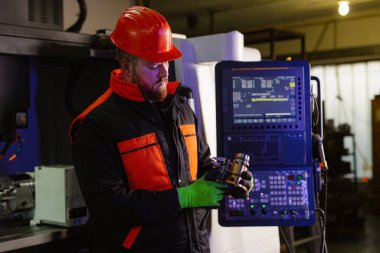 Kalite kontrol imalatı. Bir mühendisin elleri metal bir parçayı dijital vernier kalibre ile ölçer.