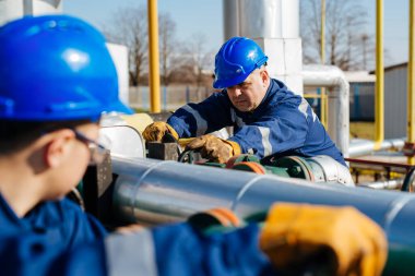 Petrol işçisi petrol platformunda vanayı çeviriyor.