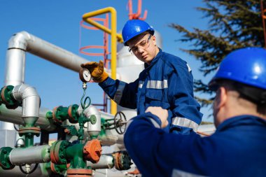 İki mühendis petrol ve doğal gaz rafineri içinde çalışıyor