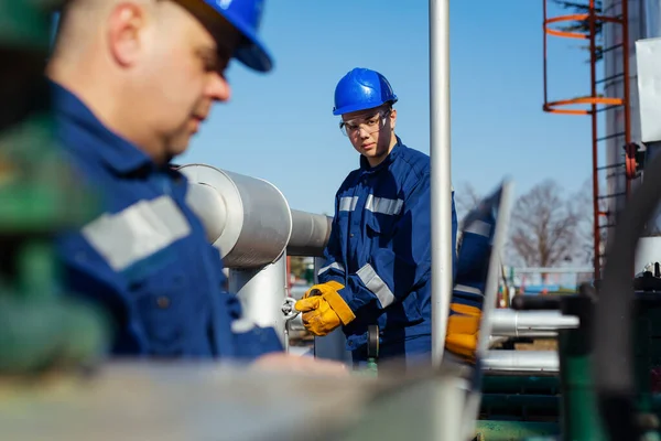 İki mühendis petrol ve doğal gaz rafineri içinde çalışıyor